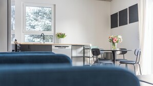 Una cocina moderna con ventana, un lavamanos y un comedor con sillas y una mesa.