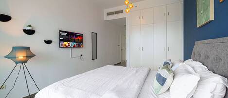 Escritorio, tabla de planchar con plancha, wifi y ropa de cama