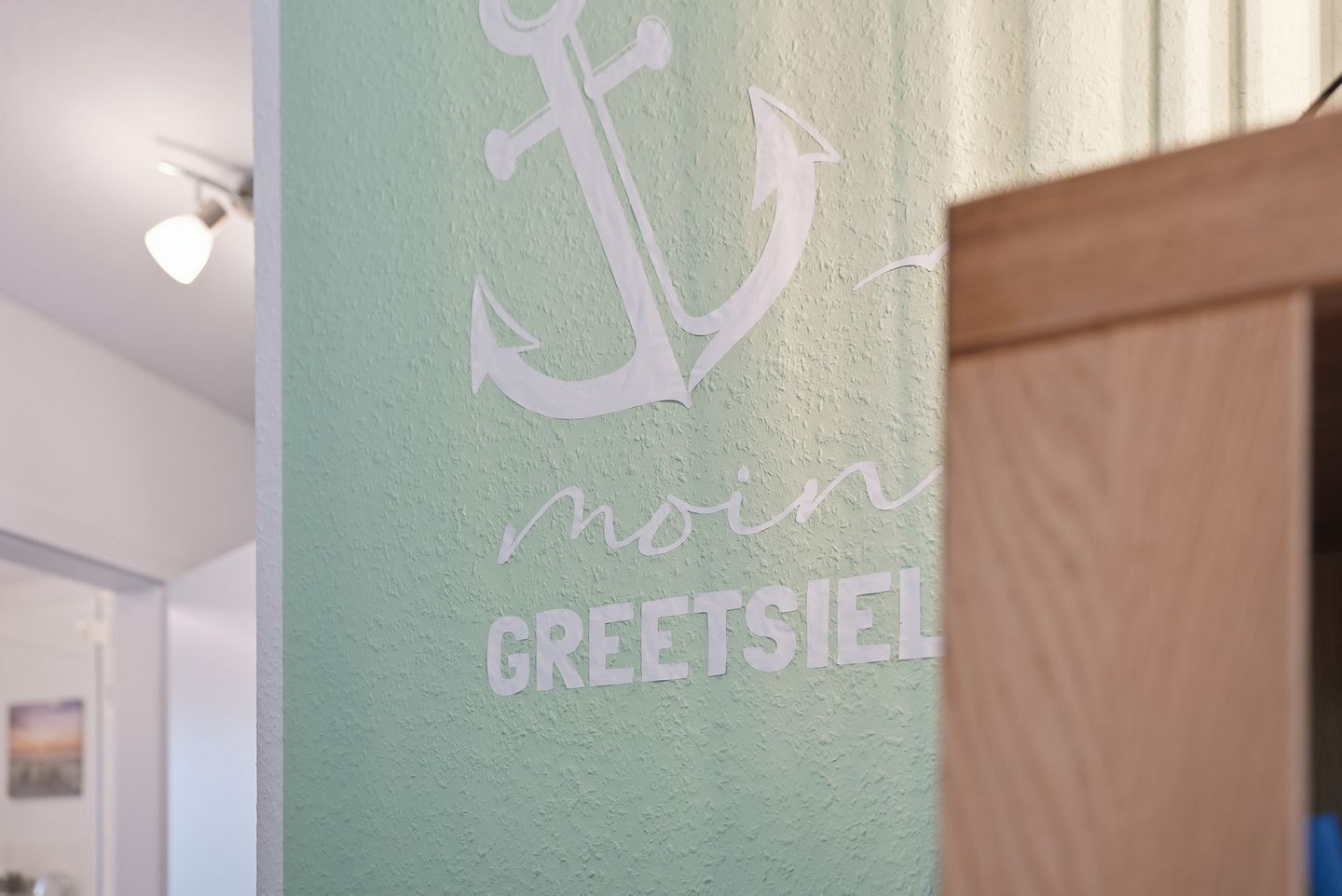 A wall with a white anchor and the words 'moin GREETSIEL.'