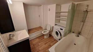 A bathroom with a toilet, washing machine, and bathtub. - Mezzanine studio full (Bordeaux)