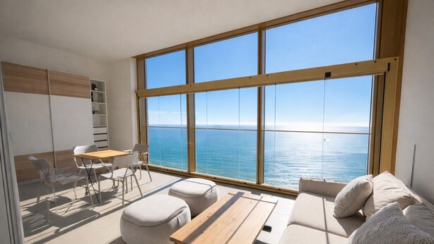 Ein modernes Zimmer mit großem Fenster, einer Couch, einem Tisch und einem Stuhl.