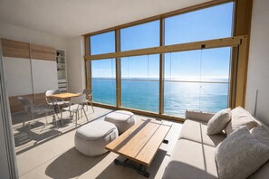 Une pièce moderne dotée d’une grande fenêtre, d’un canapé, d’une table et d’une chaise.