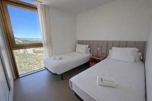 A hotel room with two beds, a large window with a view of the landscape, and a nightstand with a lamp. - Intempo by Holuxe - 356 - 35th floor (Benidorm)