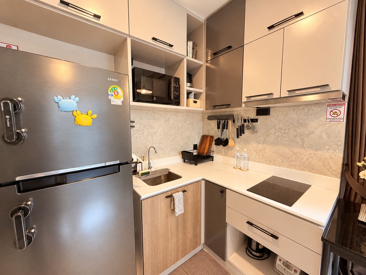 A modern kitchen with stainless steel appliances, wooden cabinets, and a built-in microwave.