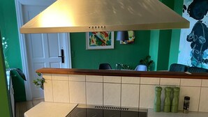 A kitchen with a stainless steel stove, a white countertop, and a green wall.