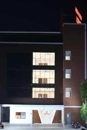 A hotel with a modern facade, large windows, and a prominent 'High View' sign.