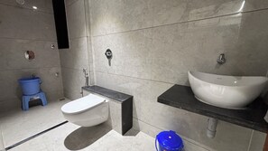 A modern bathroom with a toilet, sink, and shower.