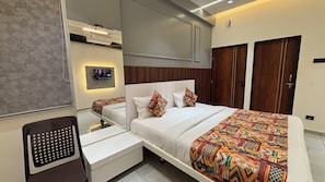 A modern hotel room with a bed, bedside tables, a TV mounted on the wall, and a wardrobe.