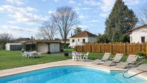 Ein Garten mit Swimmingpool, Grillplatz und umzäunter Garten.