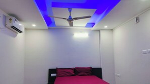 Ein Schlafzimmer mit Bett, Deckenventilator, Einbauleuchten und Klimaanlage.