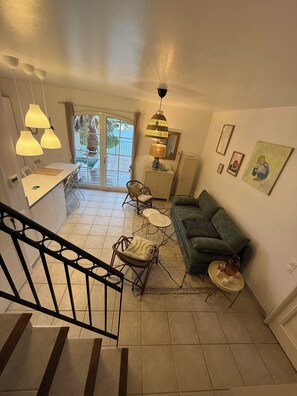 A spacious living area with a staircase, a dining table, and a sofa. - Marina des remparts (Aigues-Mortes)