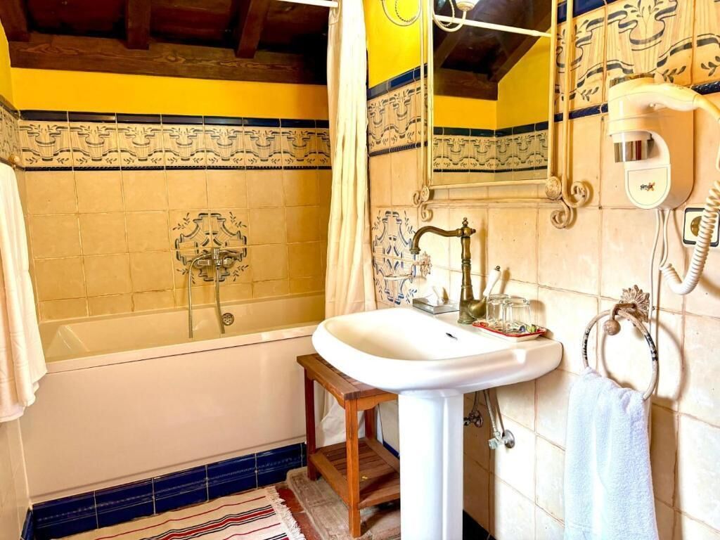 A bathroom with a bathtub, a sink, and a mirror.