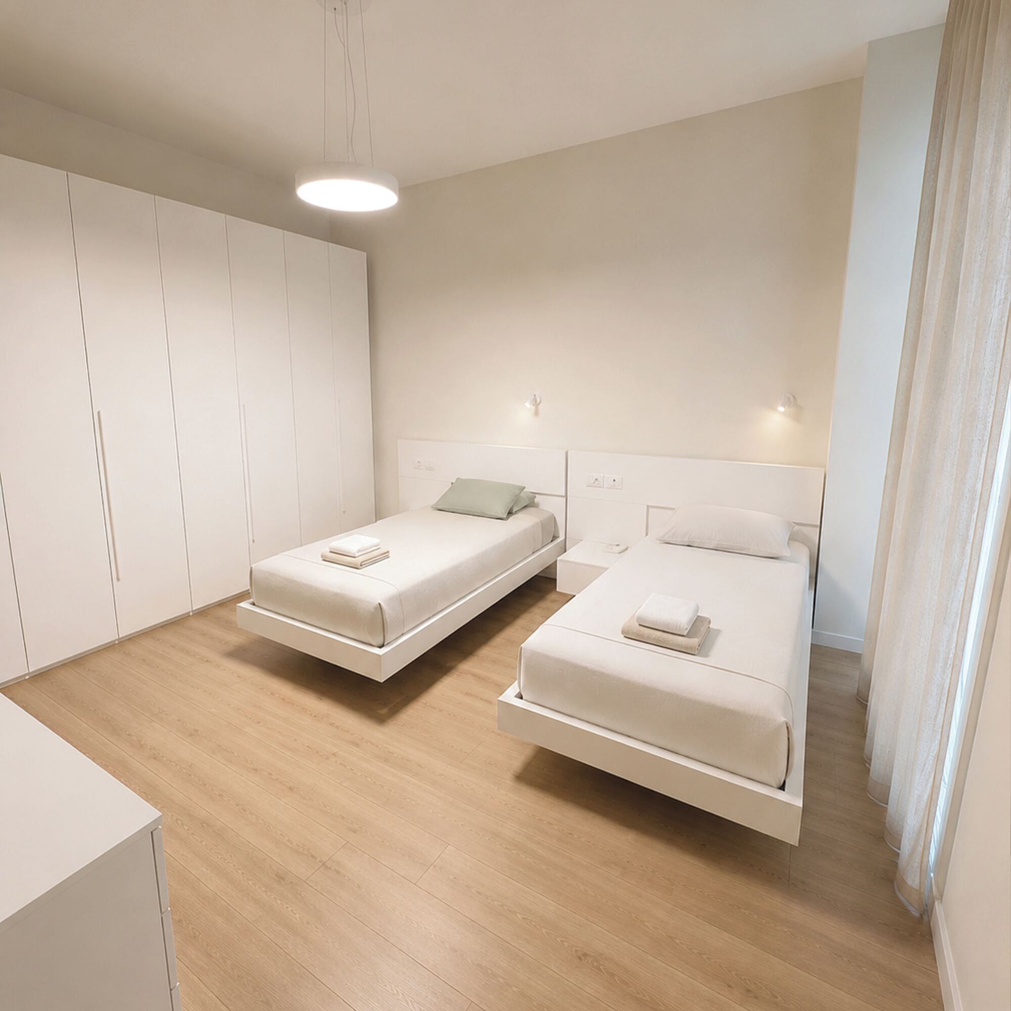 Ein modernes Schlafzimmer mit zwei Betten, einem Kleiderschrank und einer Deckenleuchte.