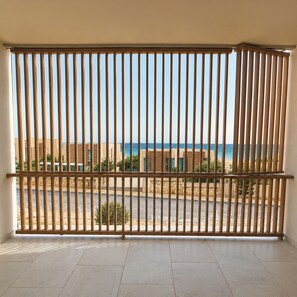 A balcony with a view of the sea and buildings.