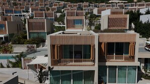 A modern resort with multiple two-story buildings, large balconies, and a pool area.