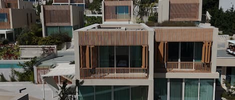 Un complexe hôtelier moderne composé de plusieurs bâtiments à deux étages, dotés de grands balcons et d’un espace piscine.