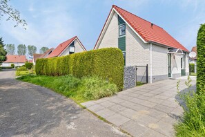 A residential area with modern houses featuring red-tiled roofs and white brick exteriors. - Stay at Holiday Home Schoneveld 249 at Holiday Park Schoneveld. This dog-friendly property has an enclosed garden and a bedroom downstairs. (Breskens)