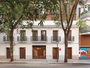 Un bâtiment doté de nombreuses fenêtres, d’une porte et d’un lampadaire.
