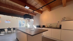 Eine moderne Küche mit Kochinsel, weißen Schränken und Holzboden.