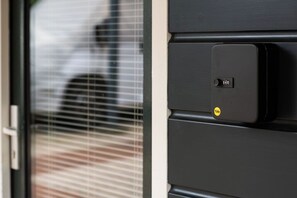 Een deur met een Yale slot en een raam met zonwering.