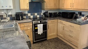 A kitchen with a gas stove, oven, microwave, and a sink. - use With Modern Comforts (Nottingham)