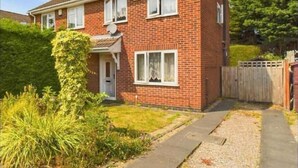 A two-story brick house with a front garden, a wooden fence, and a satellite dish. - use With Modern Comforts (Nottingham)