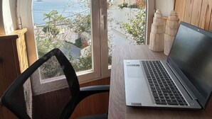 A laptop on a table with a view of the sea and buildings. - CASA EVASION at the foot of the beach, incredible views surrounded by a beautiful garden. (Almuñécar)