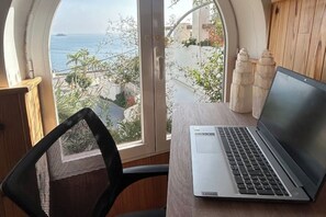 A laptop on a table with a view of the sea and buildings. - CASA EVASION at the foot of the beach, incredible views surrounded by a beautiful garden. (Almuñécar)