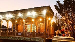 A traditional building with ornate wooden carvings and a balcony with potted plants. - DeLaila Luxury Houseboat by Shahnawaz  (Srinagar)