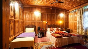 A traditional room with two beds, ornate wooden paneling, and patterned rugs. - DeLaila Luxury Houseboat by Shahnawaz  (Srinagar)