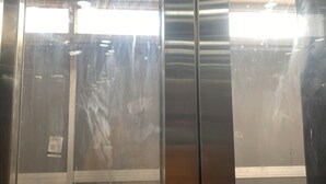 A metallic elevator interior with reflective surfaces and a central control panel. - Vishal Banquet & Marriage Hall (Bodh Gaya)