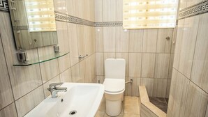 Un bagno moderno con lavandino, water e doccia bianchi.