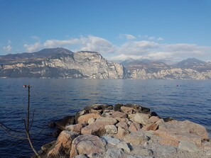 Una costa rocosa con una vista despejada de montañas al fondo.