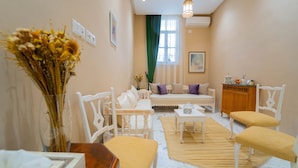 A cozy room with a bed, a desk, and a chair. There is a vase with dried flowers on a table. - Dar Majoul (Tunis)