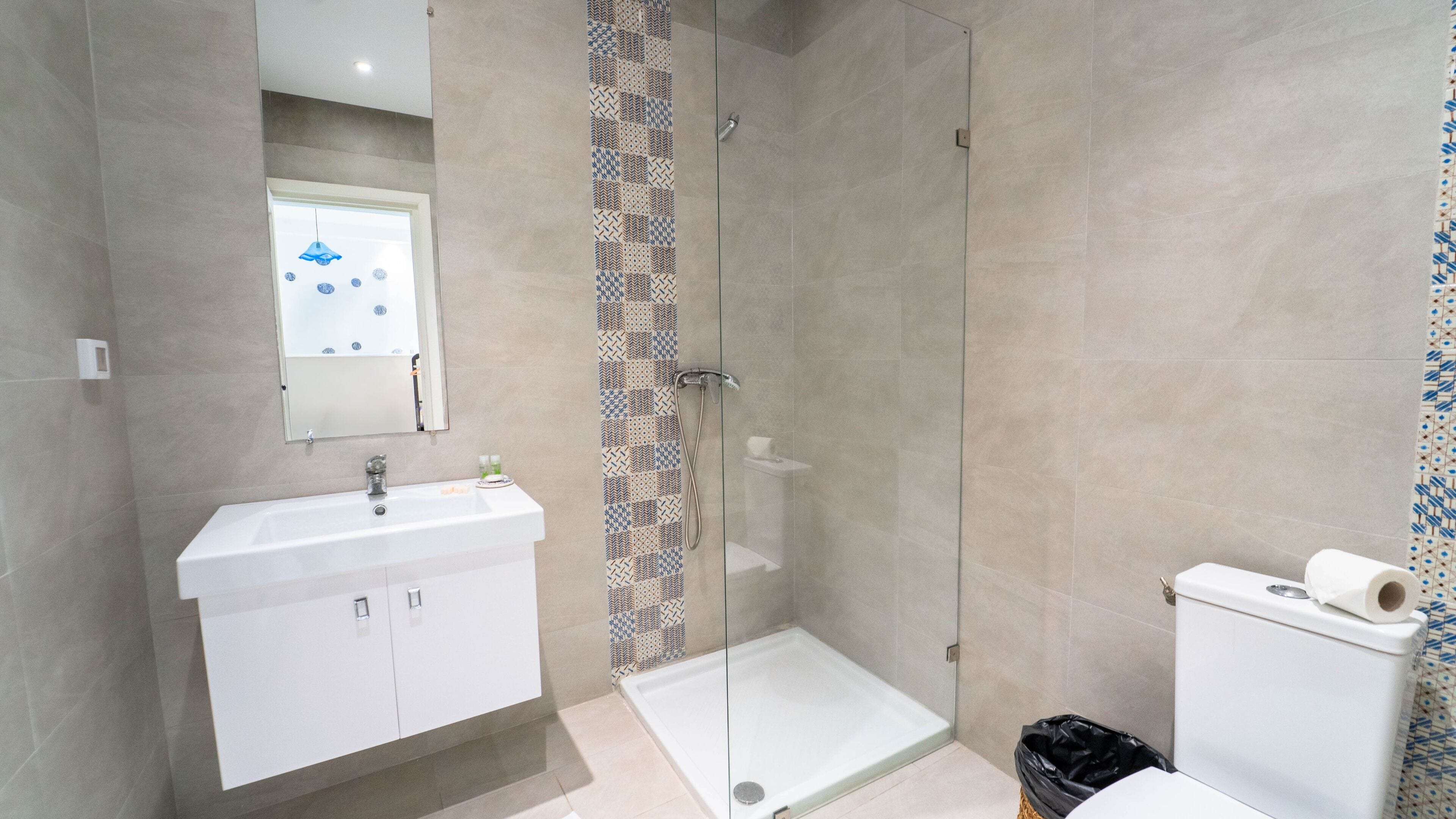 Un baño moderno con ducha, inodoro y lavamanos.