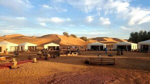 A desert resort with multiple tents, outdoor seating, and a sandy landscape. - Ksar Merzouga Luxury Camp (Merzouga)