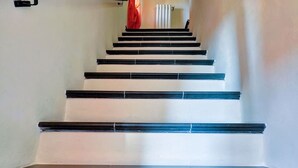 Una scala con ringhiere nere e pareti bianche.