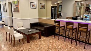 A lobby with a reception desk, seating area with sofas and chairs, and a tiled floor. - Thomas Hotel Budapest (Budapest)