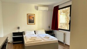 A bedroom with a bed, bedside tables, a desk, and a window with curtains. - Thomas Hotel Budapest (Budapest)
