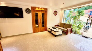 Una sala de estar moderna con un sofá, una mesa de centro, un televisor y una puerta de madera.