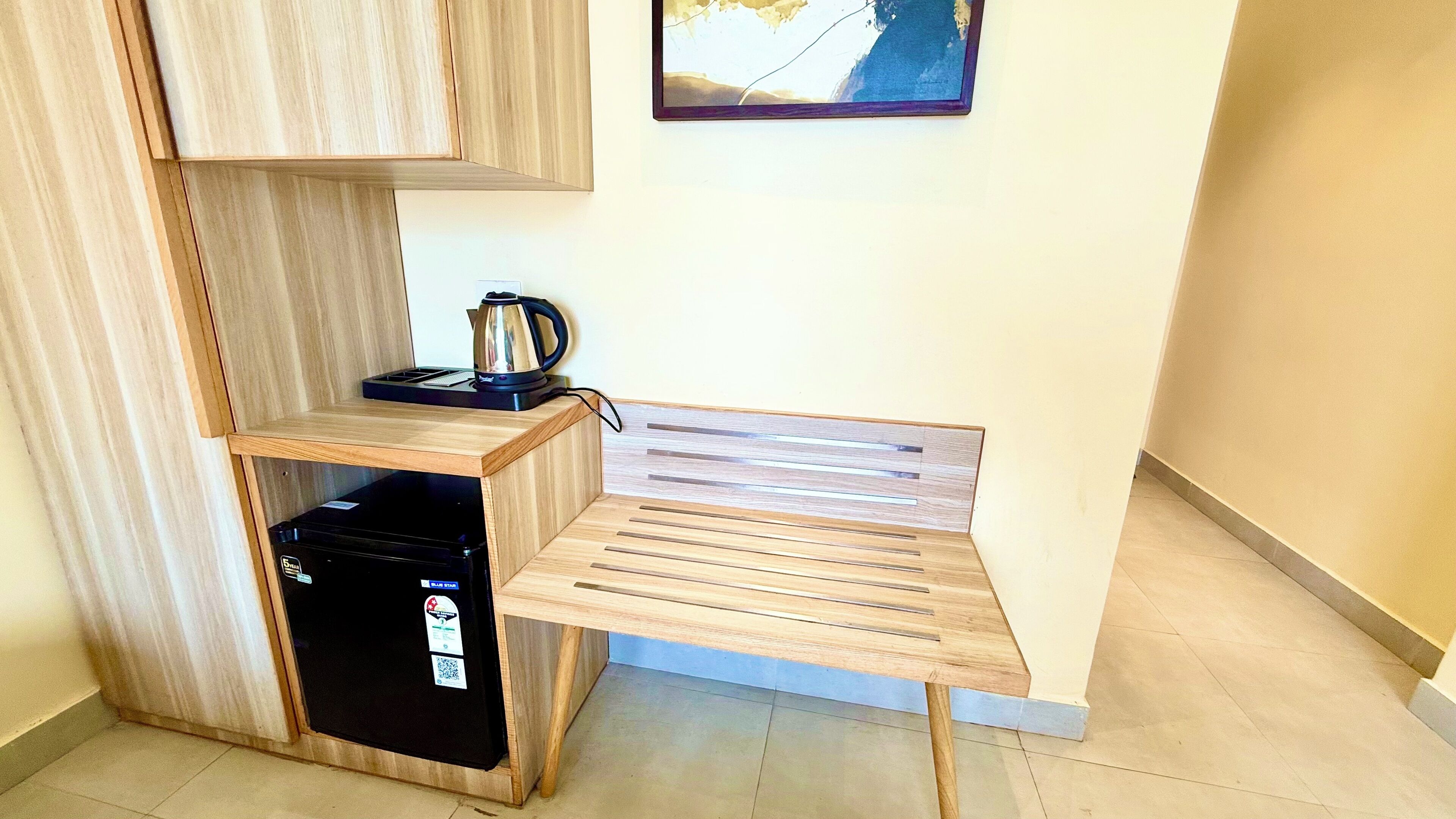 A compact kitchenette with a built-in refrigerator, a coffee maker, and a small countertop.