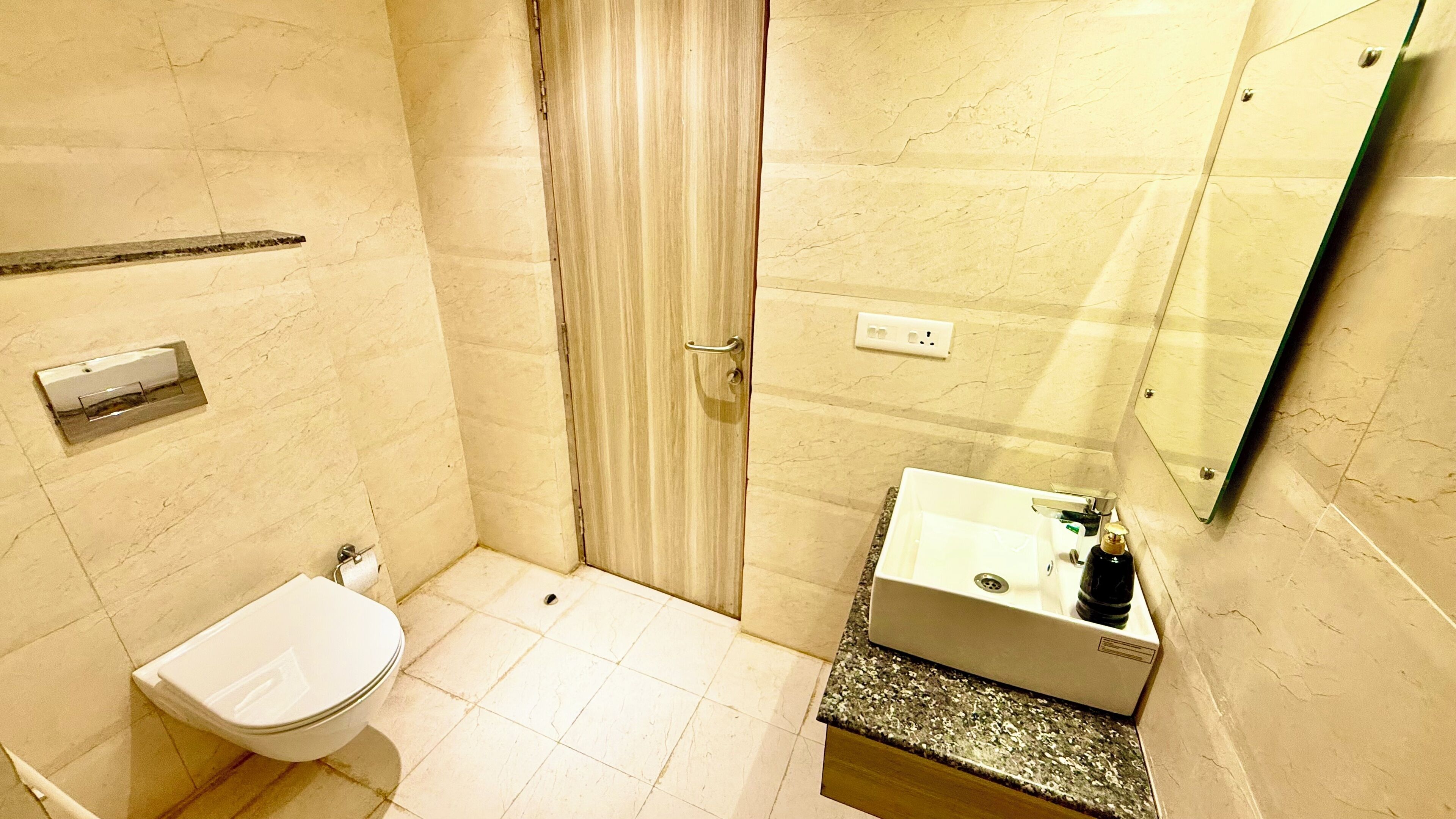 Une salle de bain comprenant des toilettes, un lavabo et un espace douche.