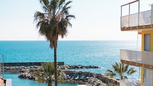 Un resort con piscina, palmeras y vista al mar.