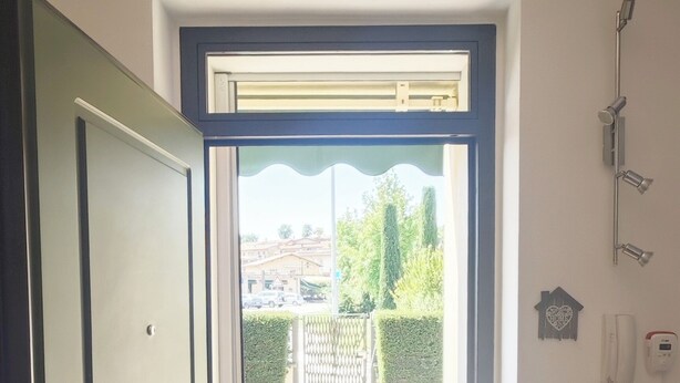 A doorway leading to a garden with a tiled floor and a door with a keyhole. - Relaxation in Holiday House Calmasino (Veneto)