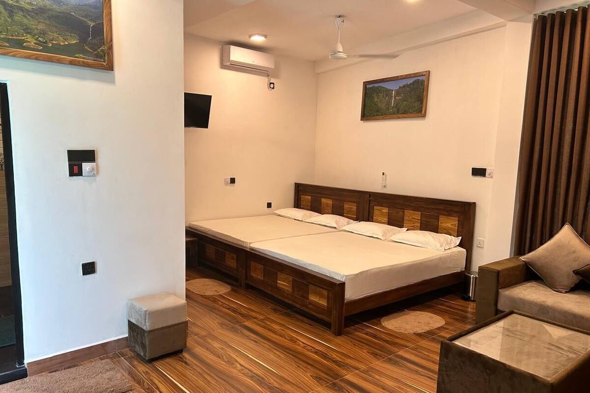 Ein Schlafzimmer mit einem Holzbett, einem Schlafsofa, einem kleinen Tisch und einem Bild an der Wand.