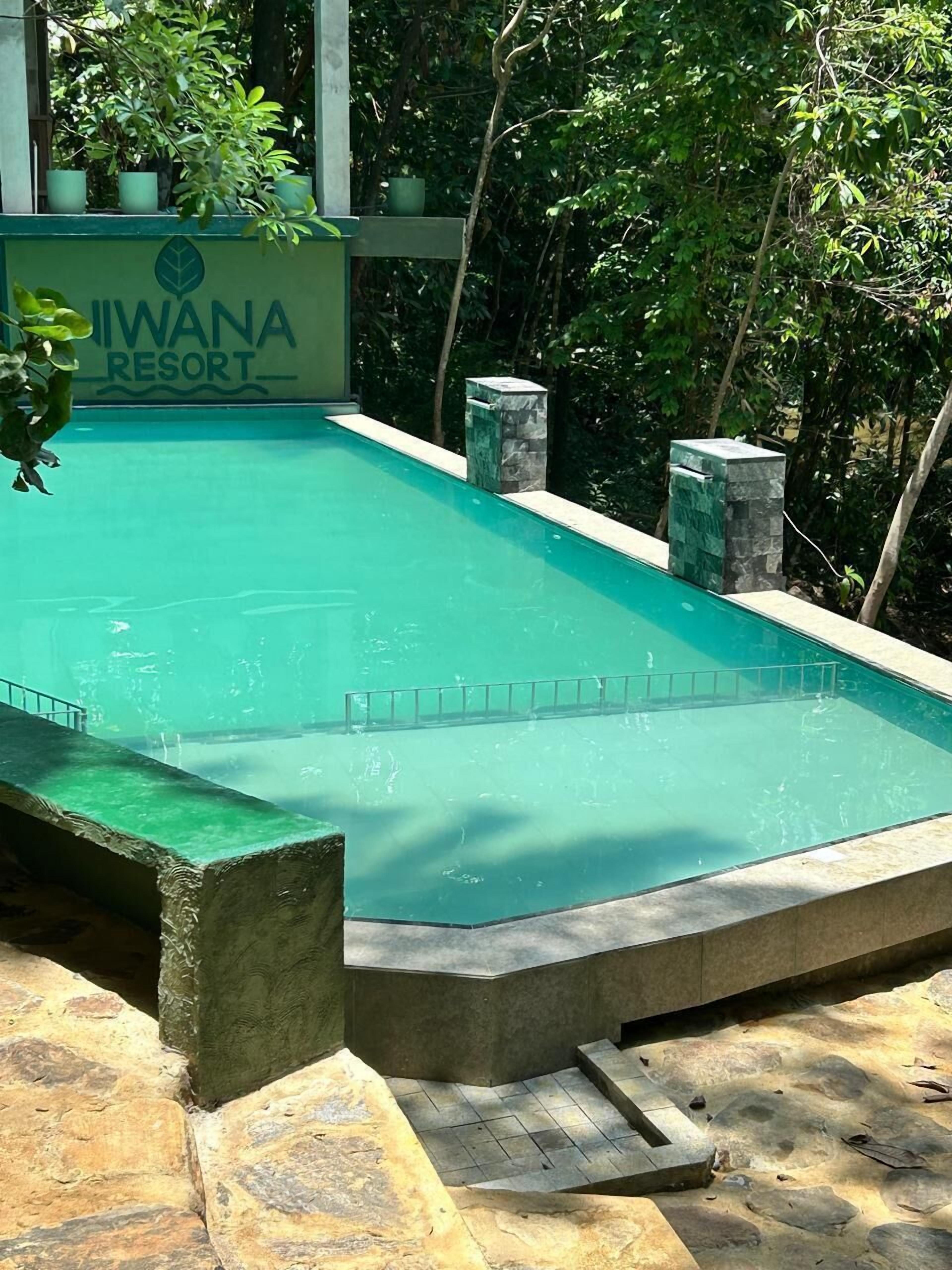 Piscina en el Resort Iwwana rodeada de follaje.