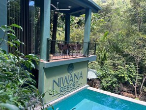 A poolside view of Niwana Resort with a clear blue pool, a covered seating area, and lush greenery surrounding the property. - Niwana Resort (Rathnapura)