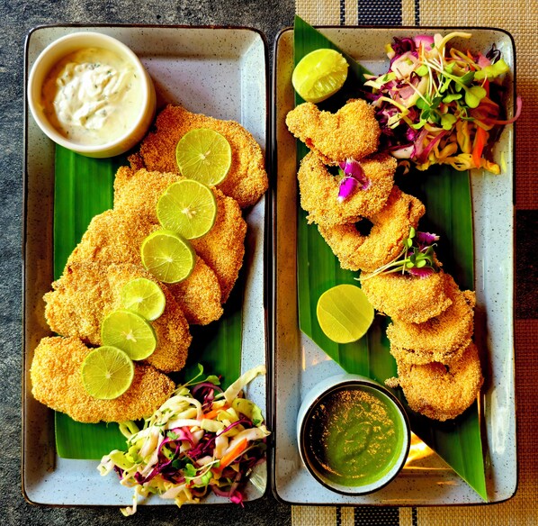 A tray with breaded and fried items, a side salad, and a bowl of sauce. - Alfred's Jewel Resort Goa (Vagator)