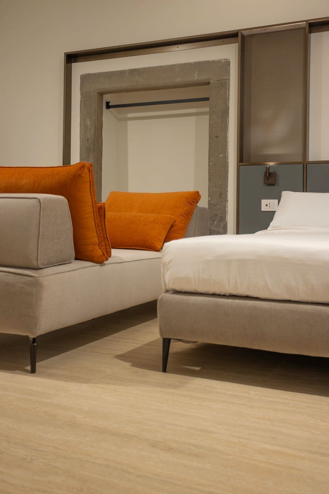 Una habitación moderna con sofá, cama y un espejo grande.