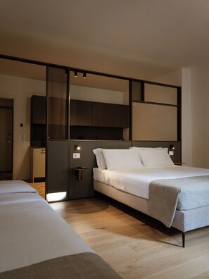 A modern bedroom with a large bed, a bedside table, and a wardrobe.